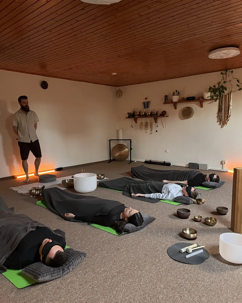 Súkromný skupinový Sound Healing - ľudia ležia prikrytí dekami v priestore s misami a gongom